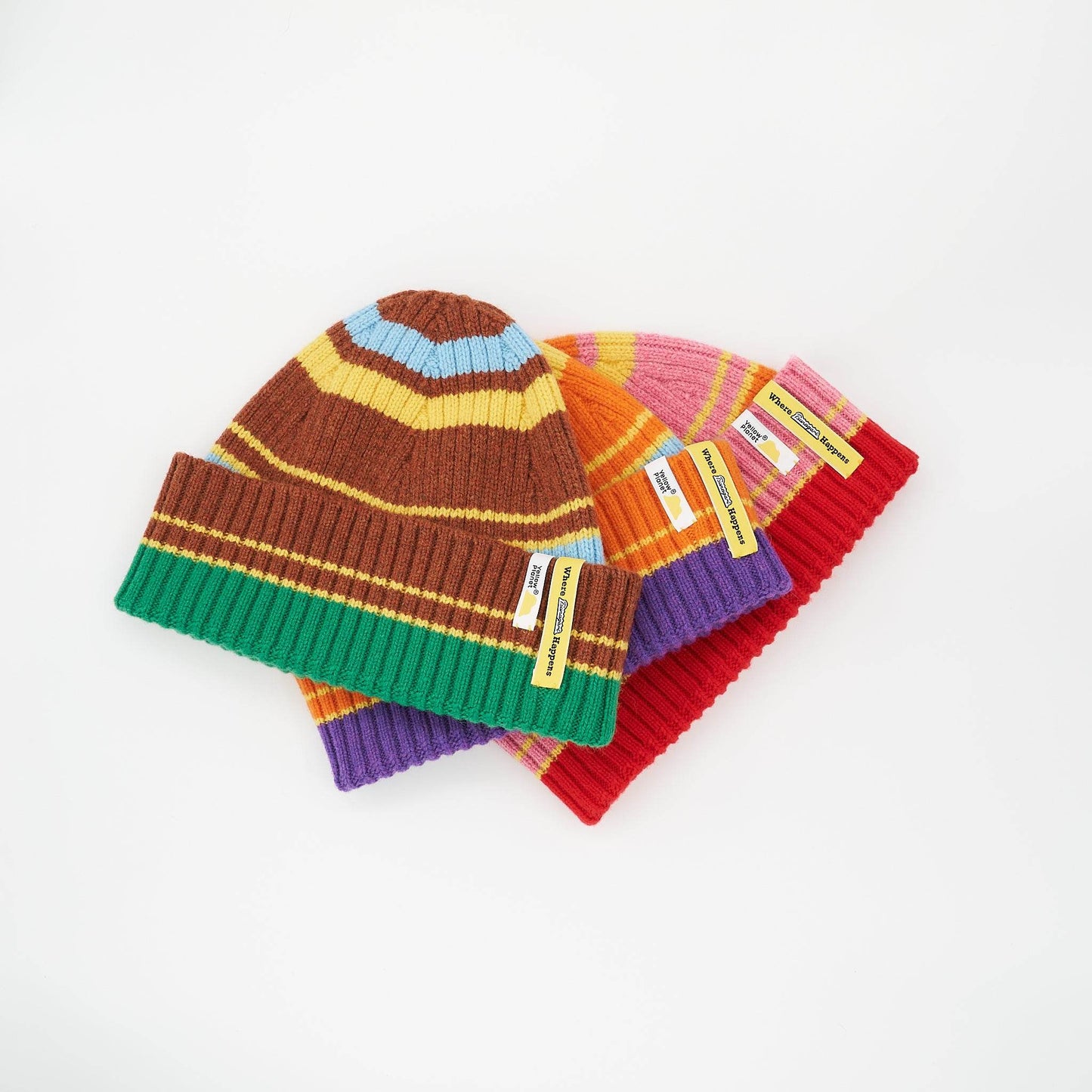 Three Color Heal Series Merino Wool Beanies with playful pom-poms, stacked in offset arrangement on a white background