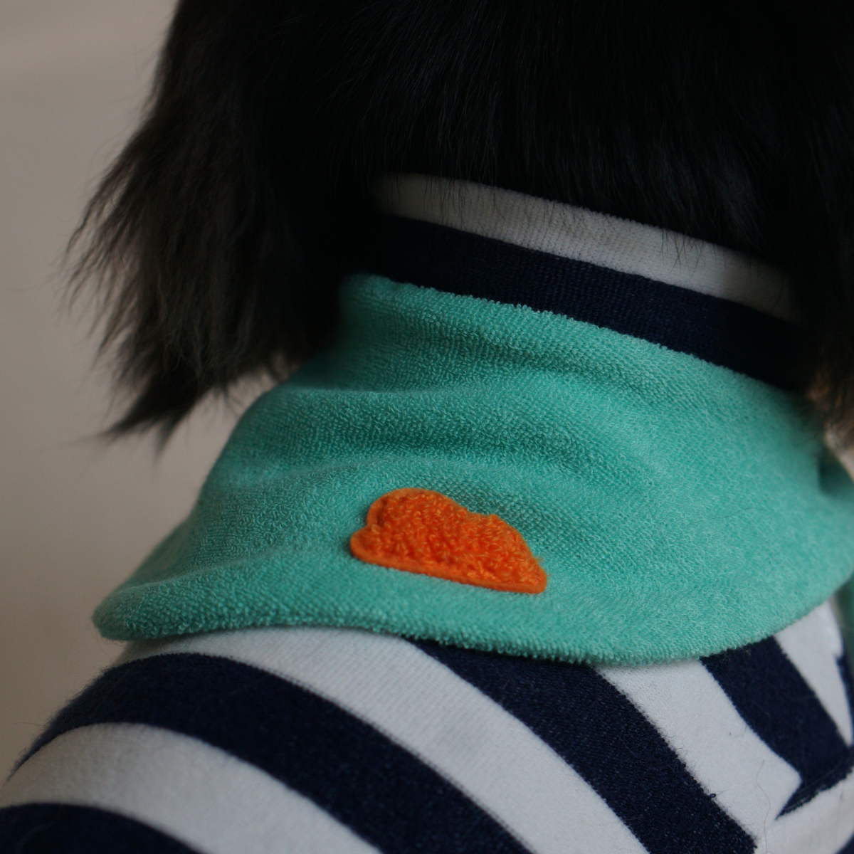Small dog wearing Colorful Daily Series Classic Stripe two-leg pet outfit in navy blue with a green yarn-dyed bandana, back view, indoors