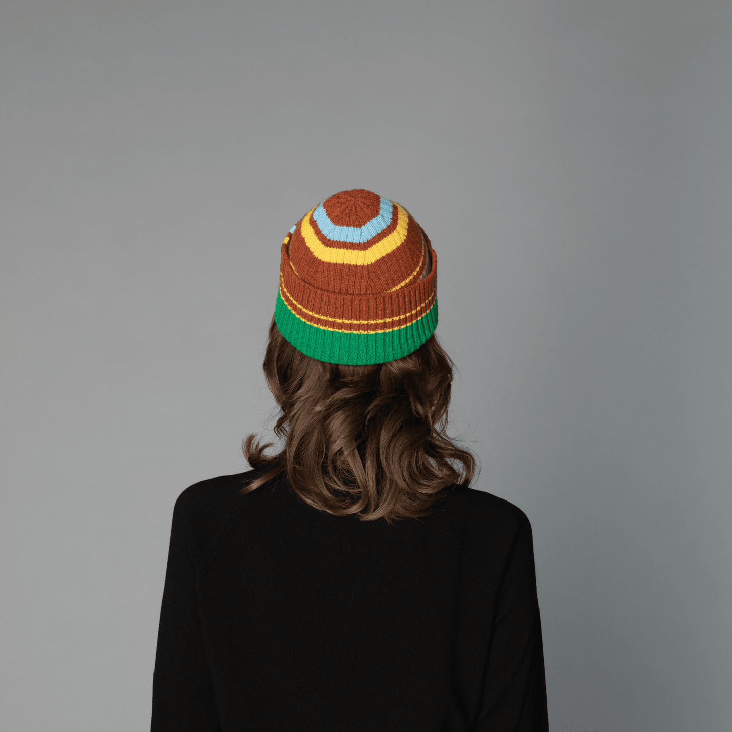 Back view of human model wearing striped wool beanie-chestnut