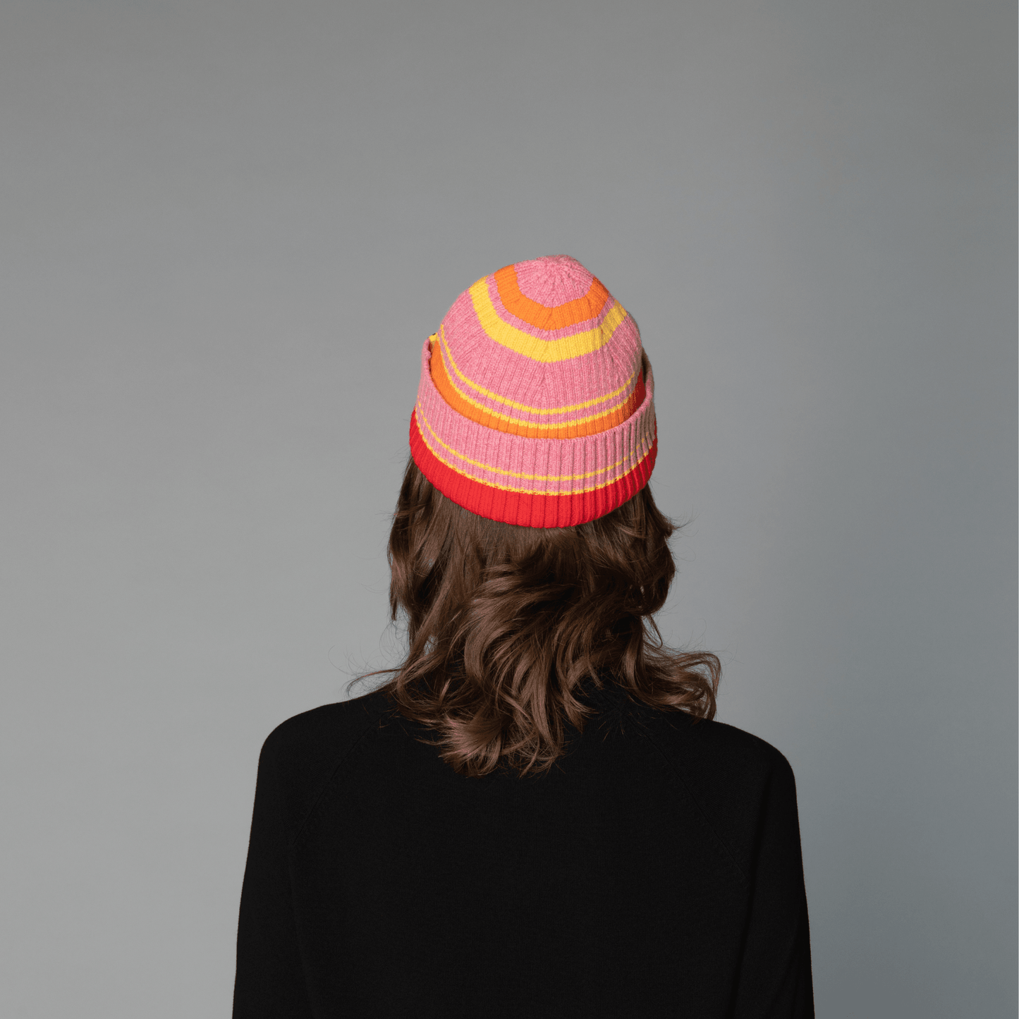 Back view of Human model wearing striped wool beanie-pink