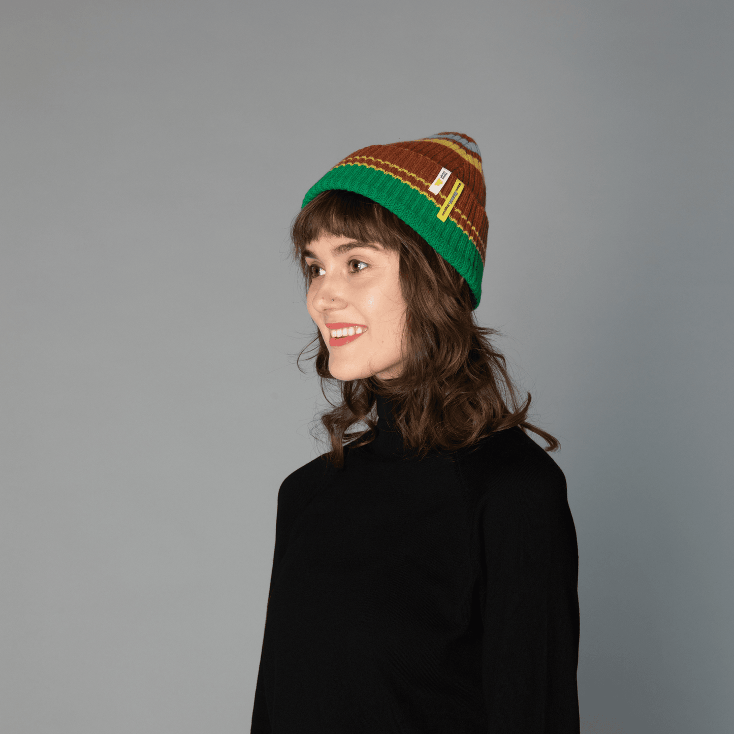 side view of human model wearing striped wool beanie