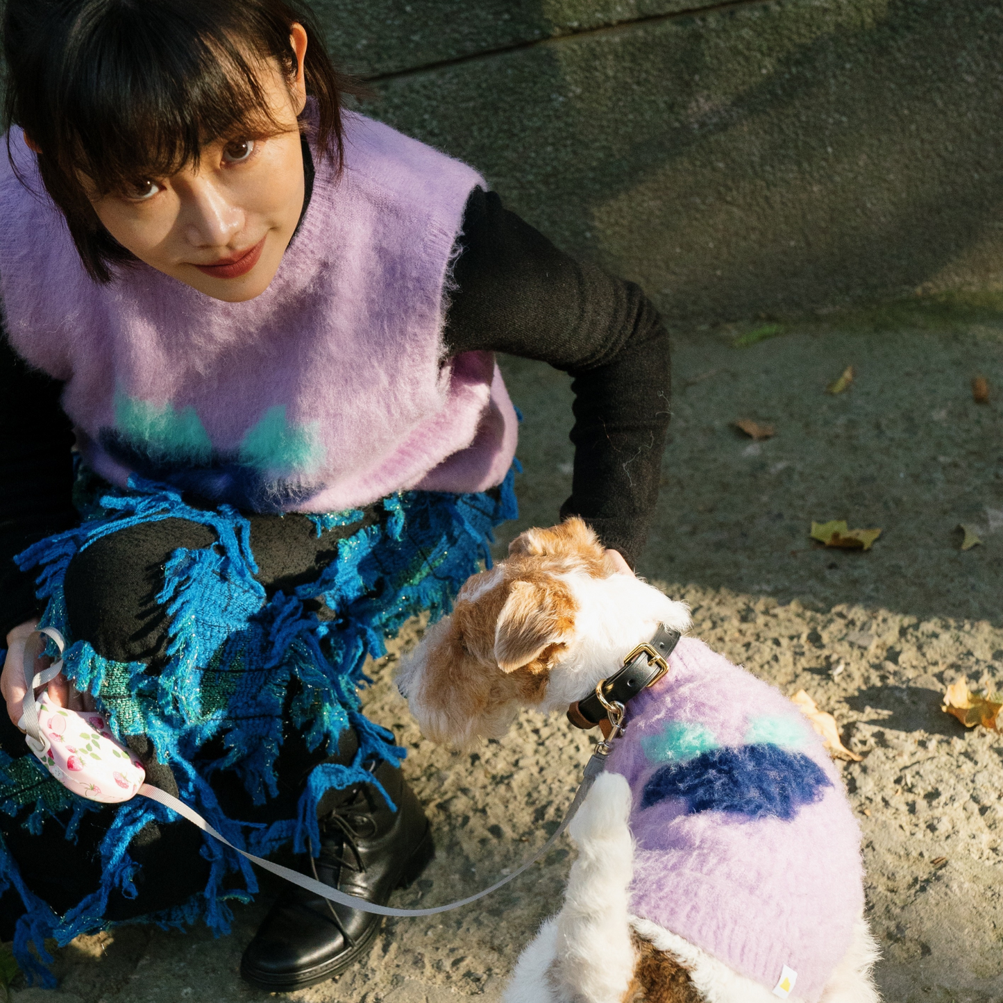 Human and dog wearing matching Yellow Market knit vests-purple grape