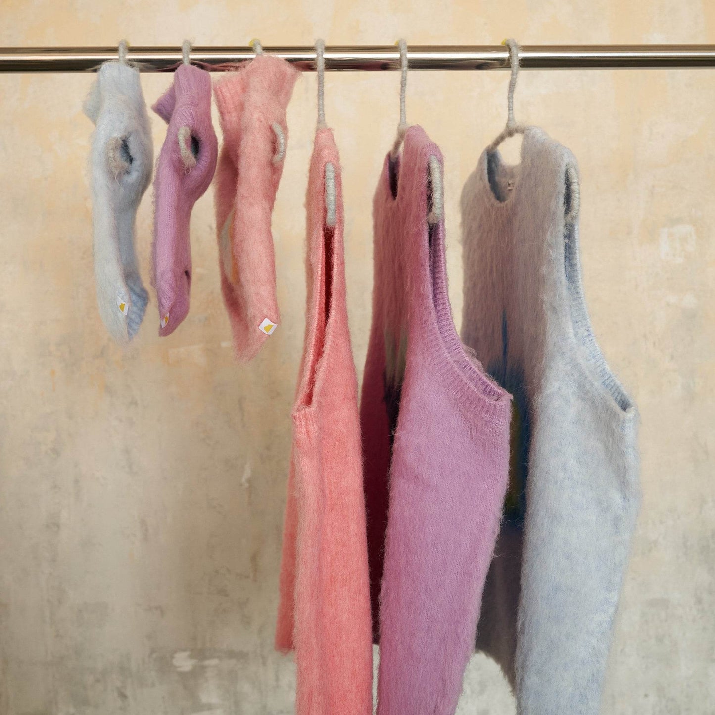 Matching Yellow Market Series stretch fleece-lined knit vests hanging together, human edition and pet edition displayed side by side.