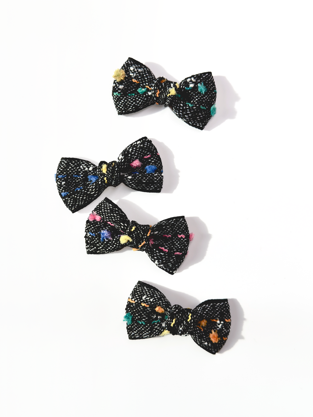 BALOVESYOU Crayon Confetti pet hair clips with colorful abstract details on black bow fabric.