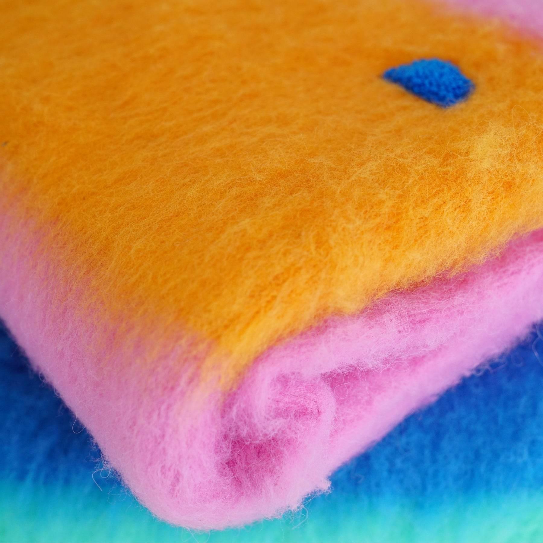 Detailed view of the signature blue intarsia mountain-style graphic on the orange section of the brushed knit sweater.