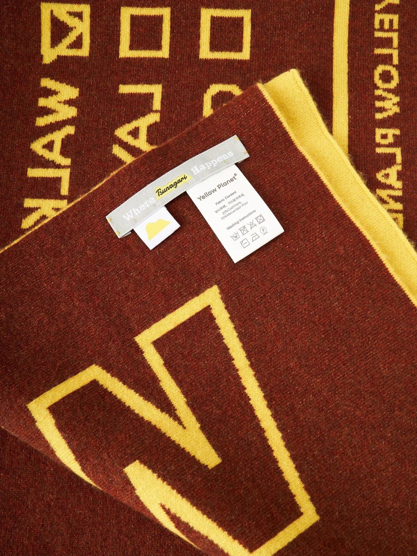 Detail shot of the brown reverse side of the scarf with the Yellow Planet brand label and material care instructions.