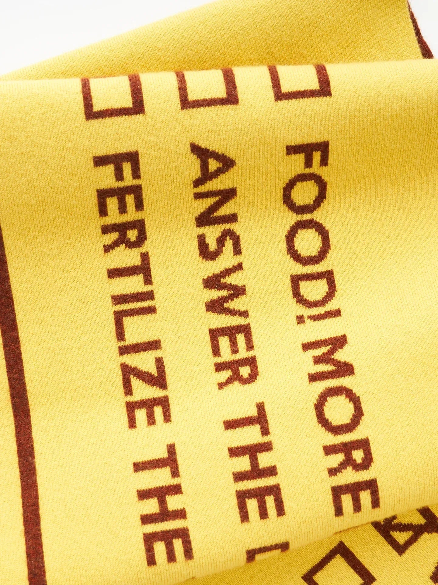 Detail shot of the brown reverse side of the scarf with the typography