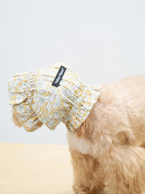 Side back view of a cream-colored dog wearing the Colorful Daily Nature's Verse Gentle Wave Snood in Daisy, showing the soft gathered shape and floral print.