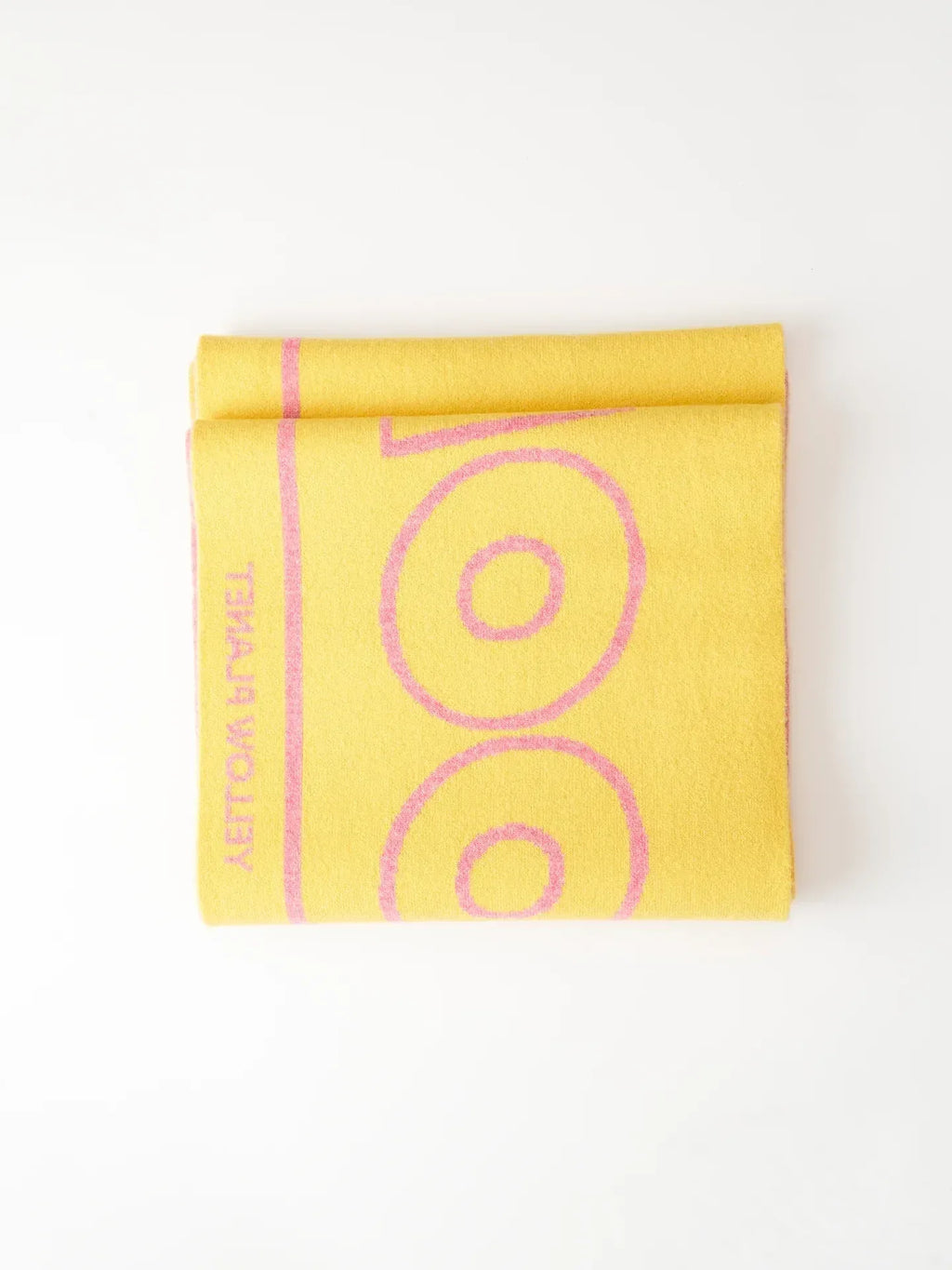 A creative lifestyle stack of the "WOOF" scarf collection on top of a "Yellow Press" book with autumnal props.