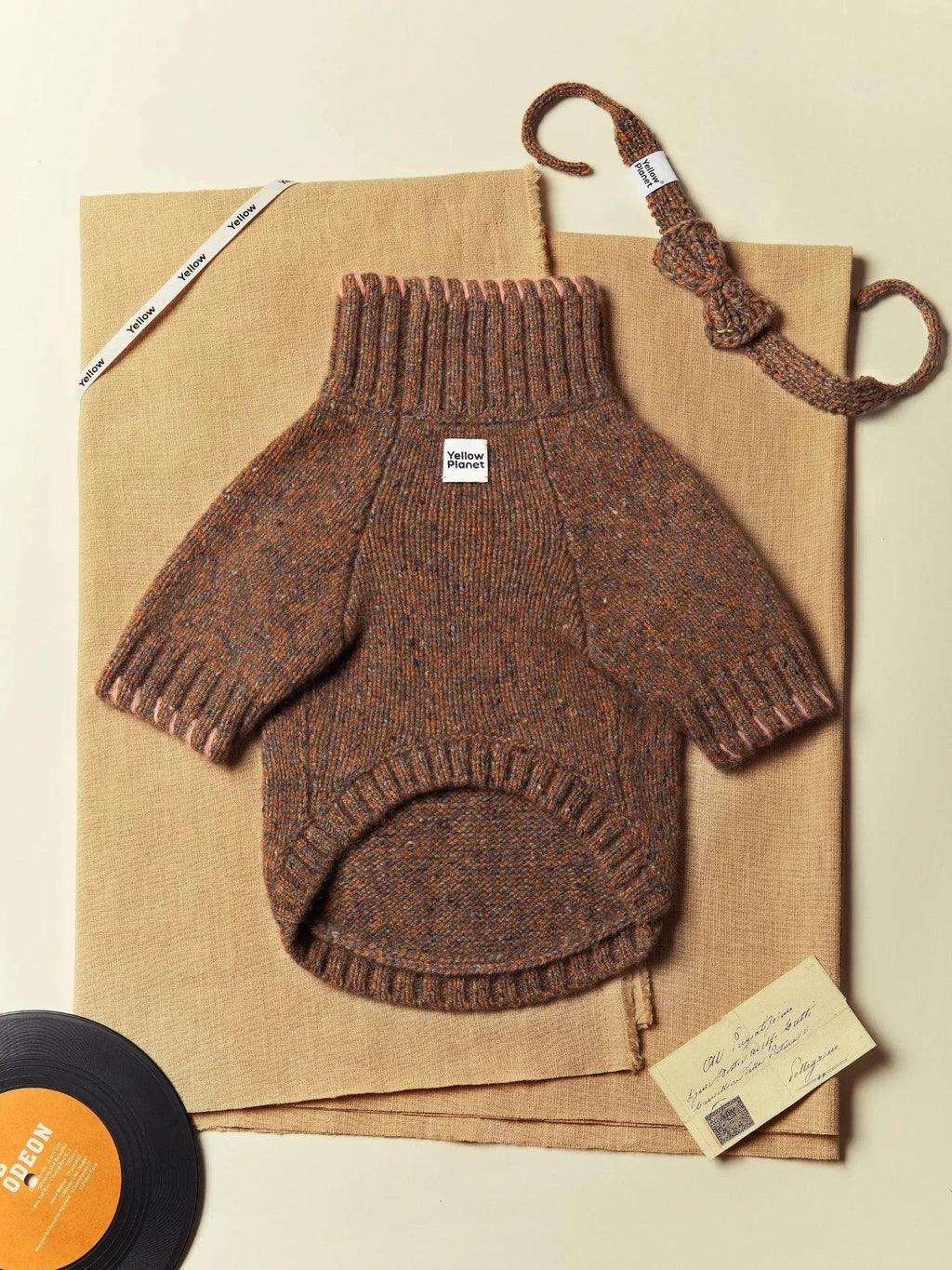 The Rust Tweed dog sweater presented as part of the "Gentle Dog" collection with retro lifestyle accessories.