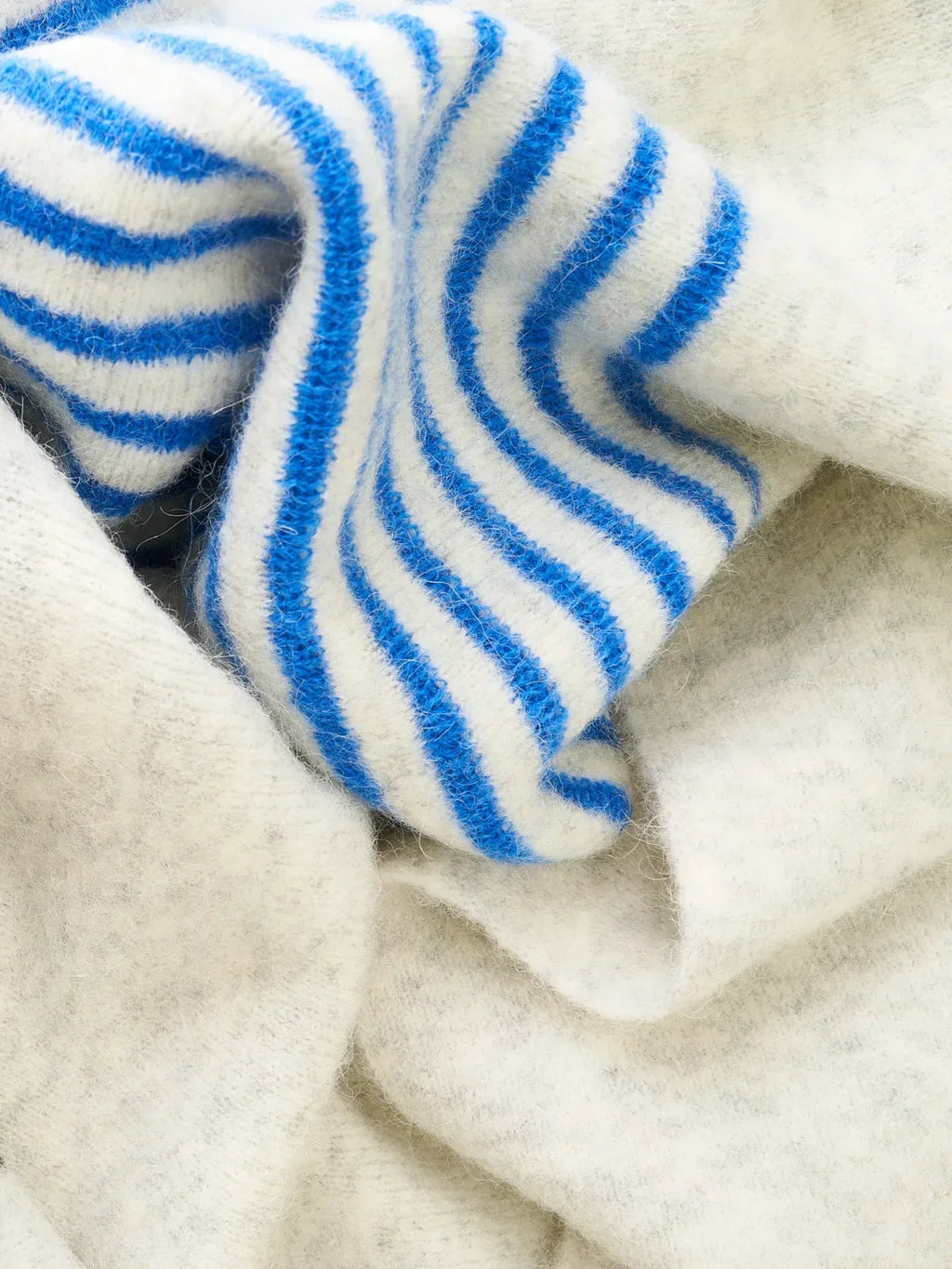 Close-up of the grey and blue-striped sections of the "MEOW" scarf, showcasing the soft, fuzzy alpaca wool blend.