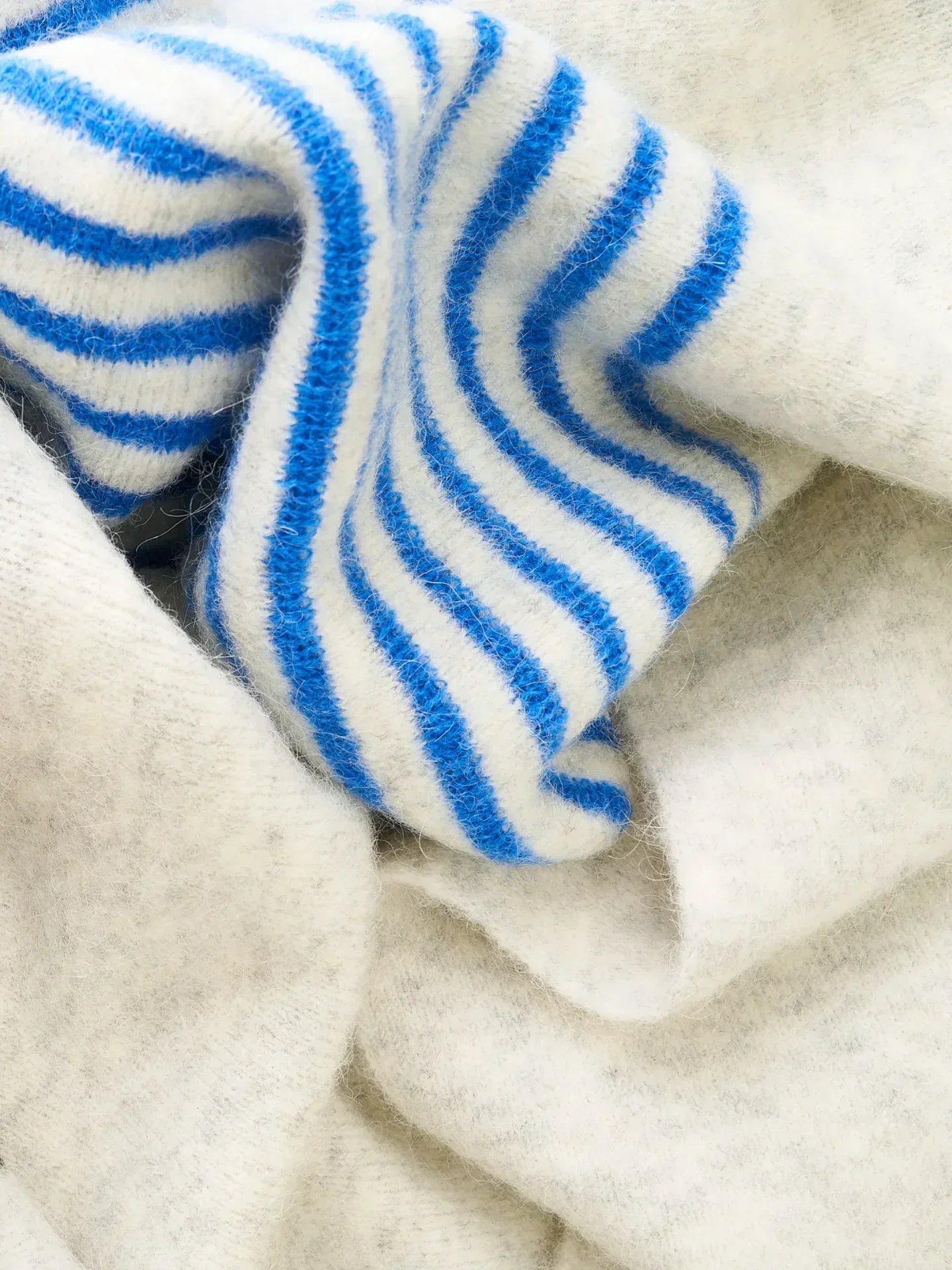 Close-up of the grey and blue-striped sections of the "MEOW" scarf, showcasing the soft, fuzzy alpaca wool blend.