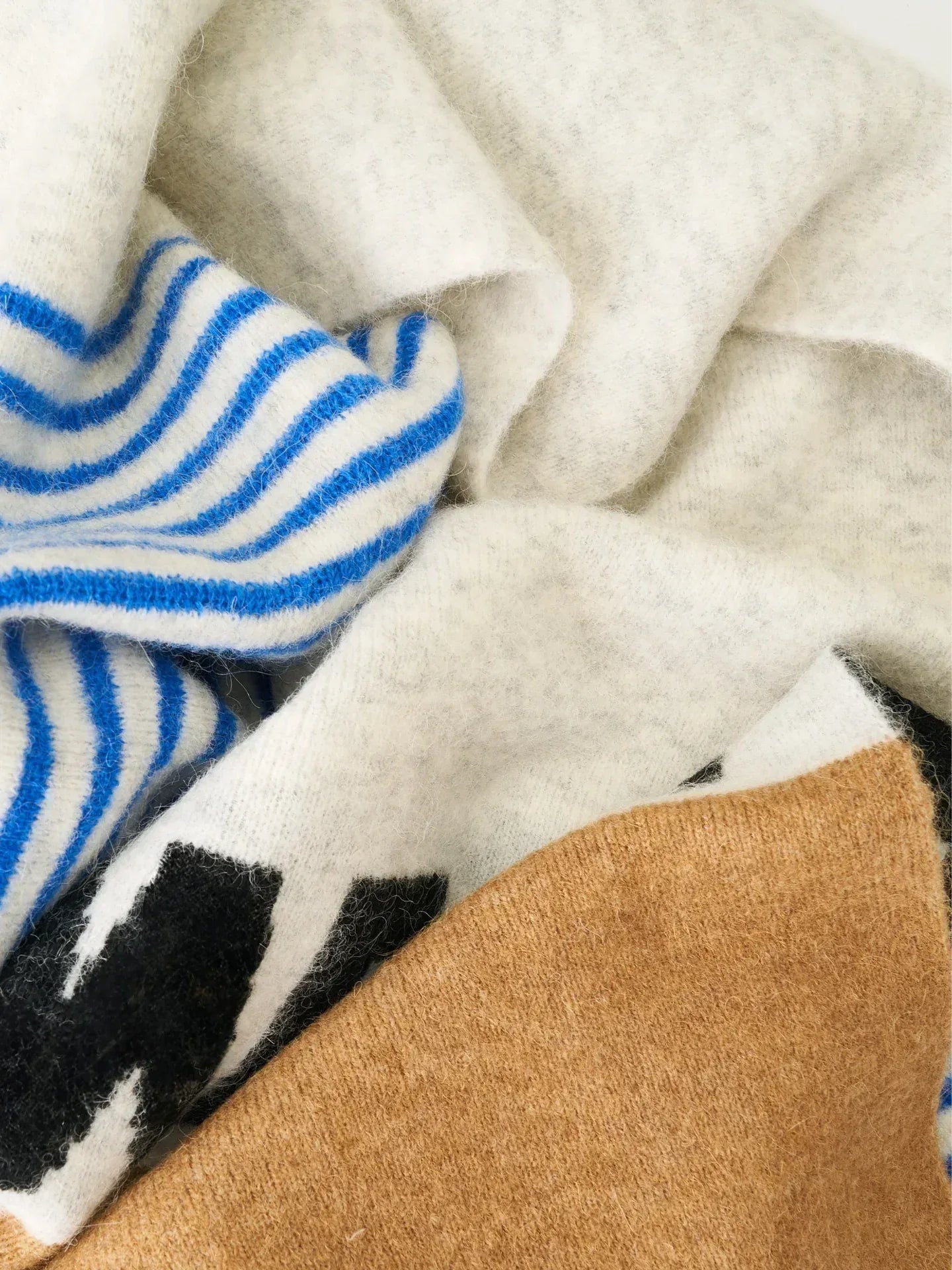 A macro shot of the high-quality mohair and alpaca wool texture, focusing on the vibrant blue and white striped pattern.