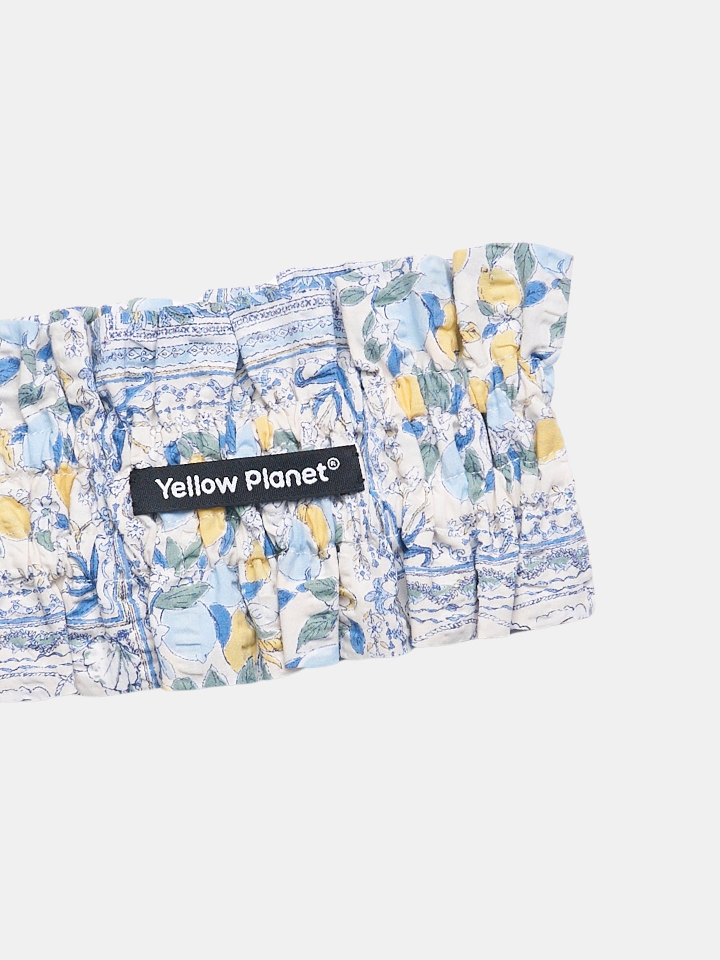 Close-up of the Amalfi printed cotton fabric and Yellow Planet label on the Nature's Verse Bow Neckpiece.