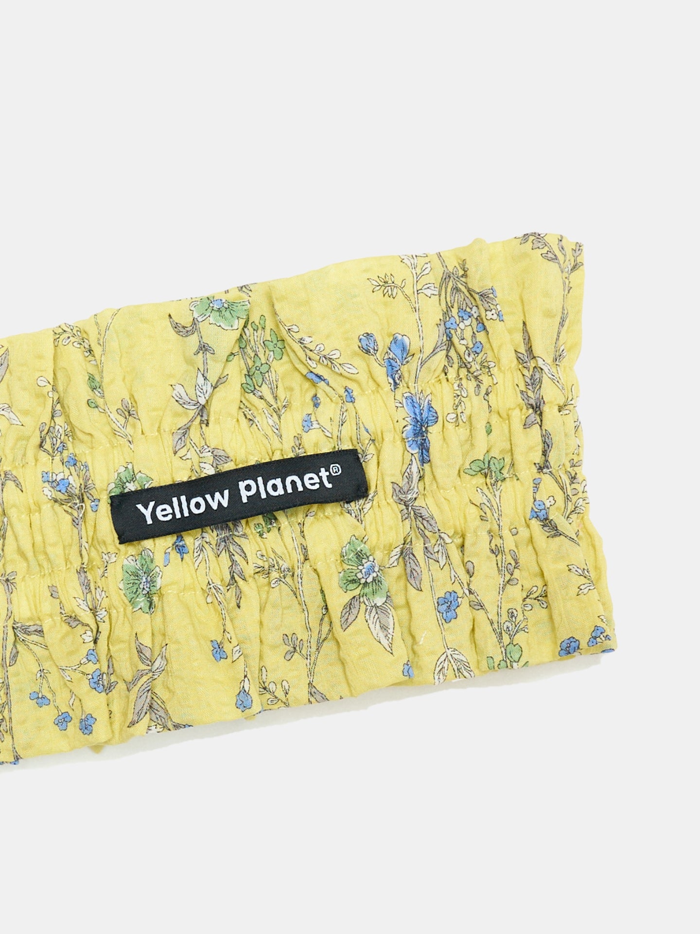 Close-up of the Forest Yellow printed cotton fabric and Yellow Planet label on the Nature's Verse Bow Neckpiece.