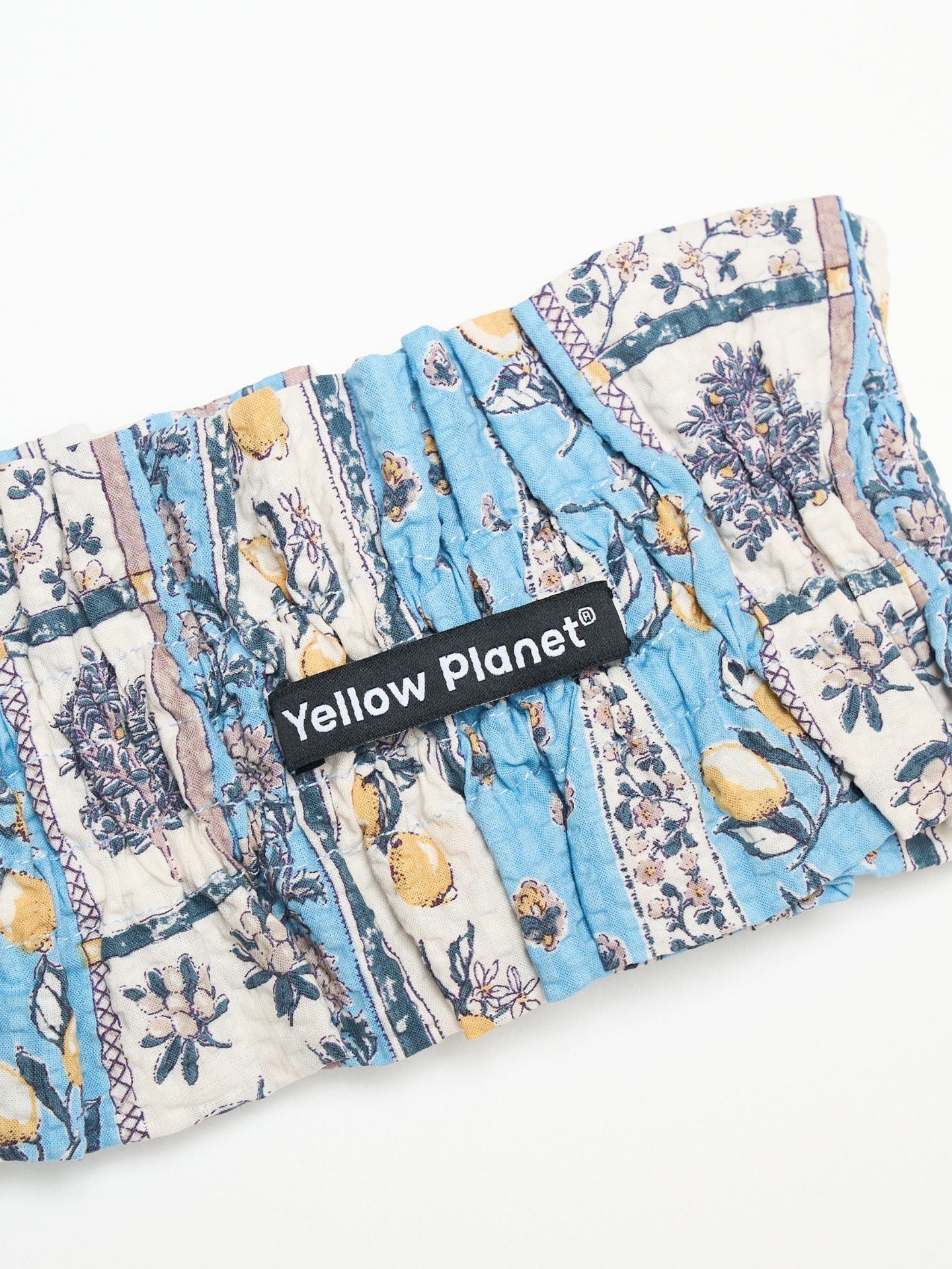 Close-up of the Limoncello printed cotton fabric and Yellow Planet label on the Nature's Verse Bow Neckpiece.