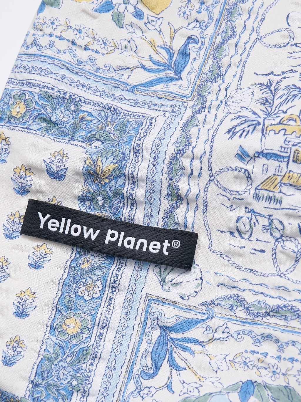 Close-up of the Amalfi printed crinkled cotton fabric and Yellow Planet label on the Gentle Wave dog ear snood.