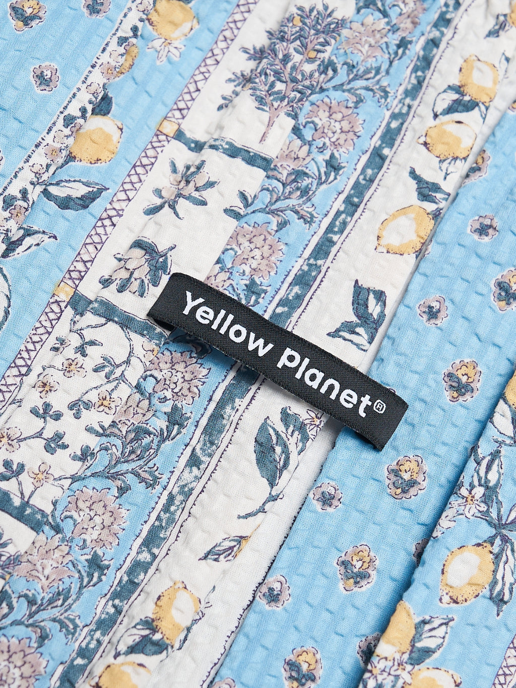 Close-up of the Limoncello printed cotton fabric and Yellow Planet label on the Gentle Wave snood.