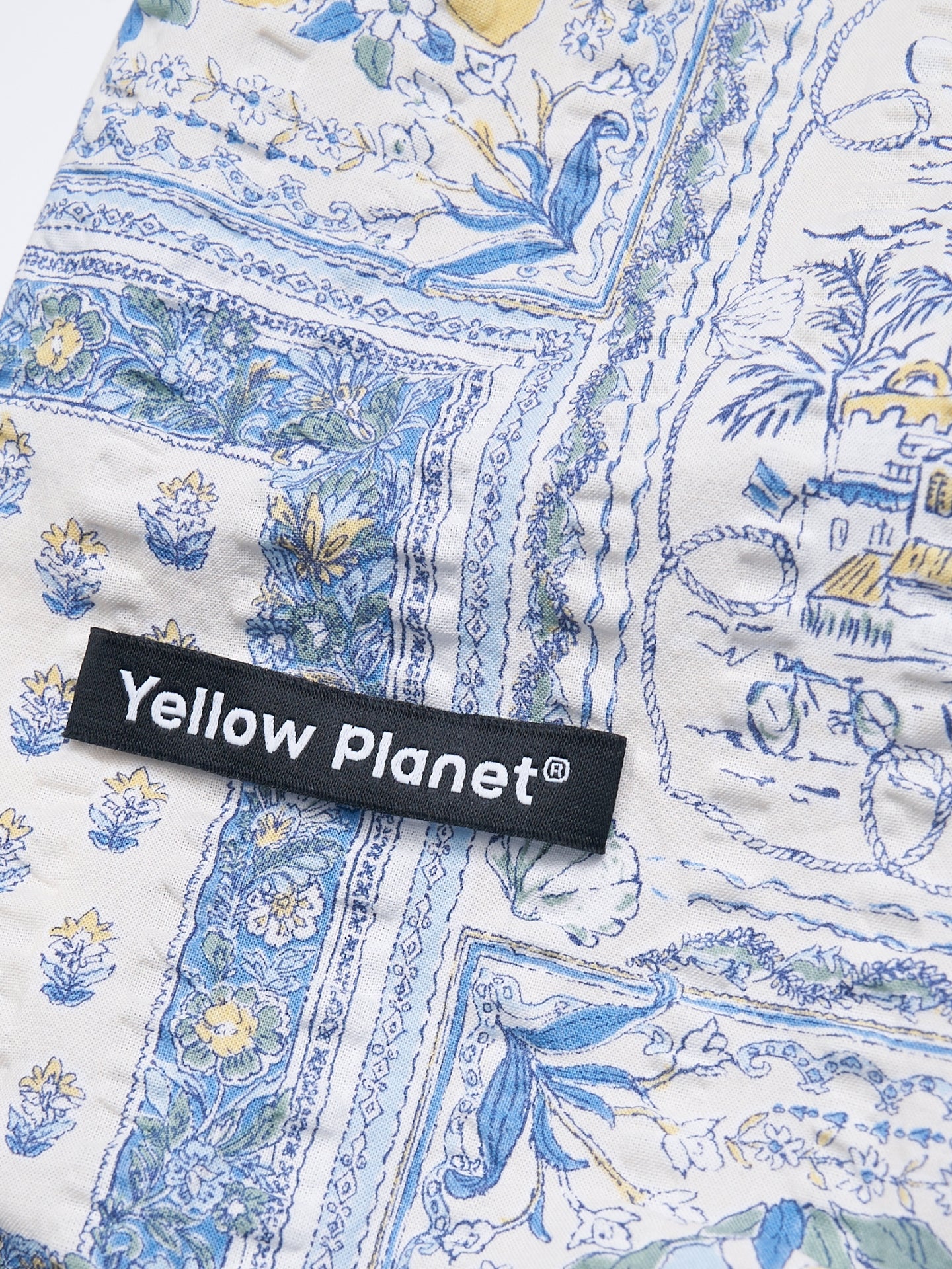 Close-up of the Amalfi printed crinkled cotton fabric and Yellow Planet label on the Gentle Wave dog tank.