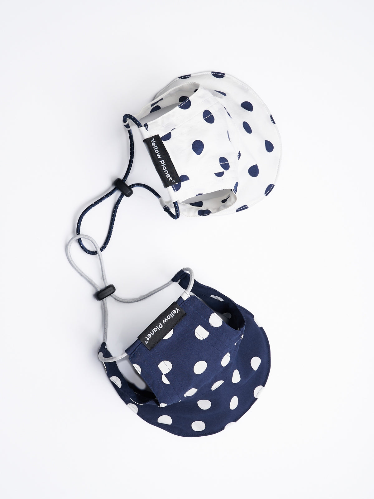 Flat lay of the Oasis Series Polka Dot UV Pet Caps in Navy and White with adjustable reflective cords.