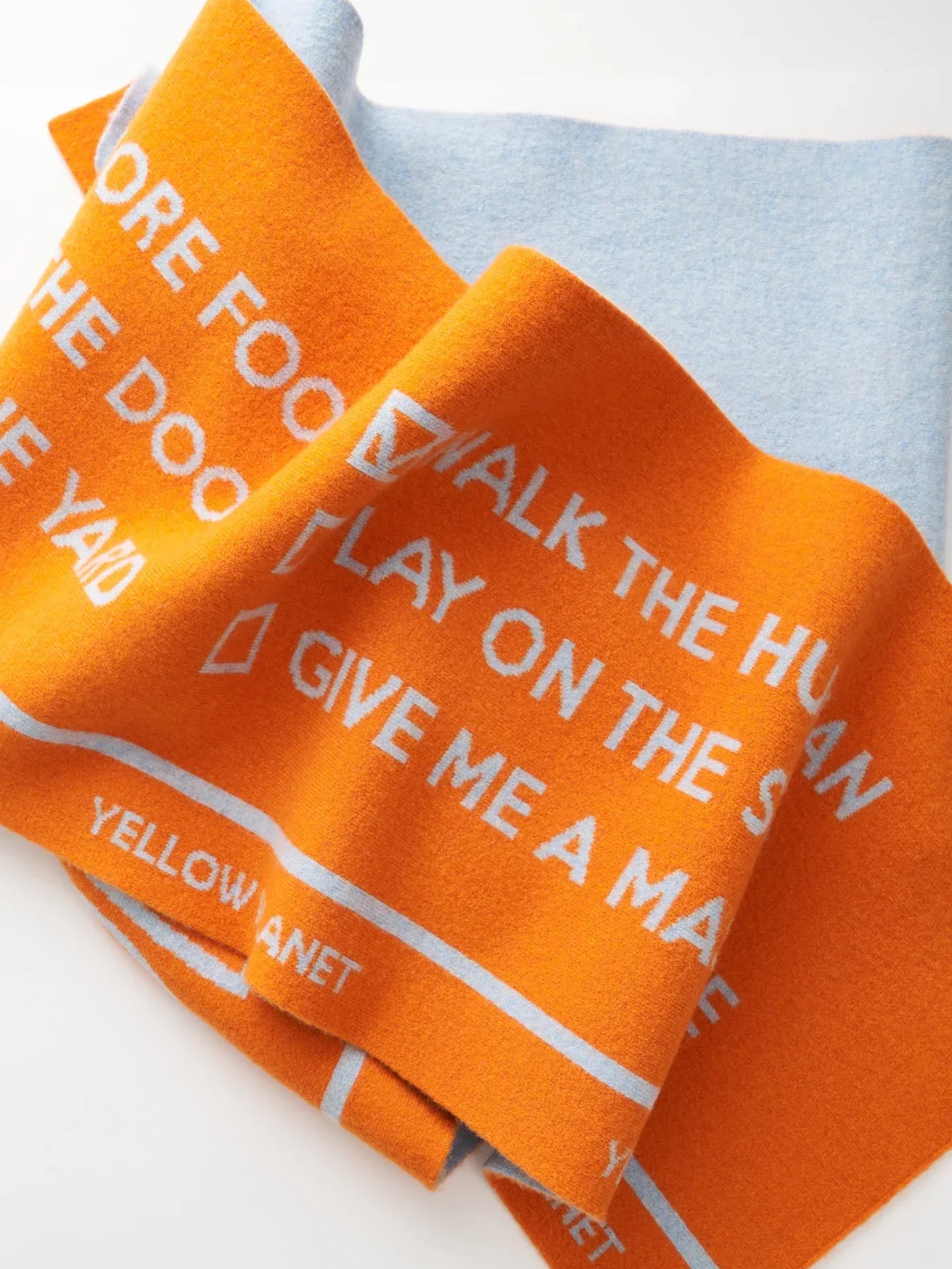 Close-up of the orange side of the scarf showing white "WOOF" typography and dog-themed checklist items.
