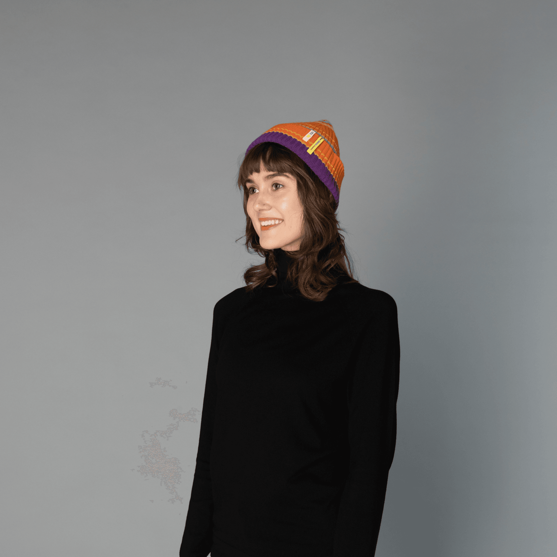 Human model wearing striped wool beanie-orange