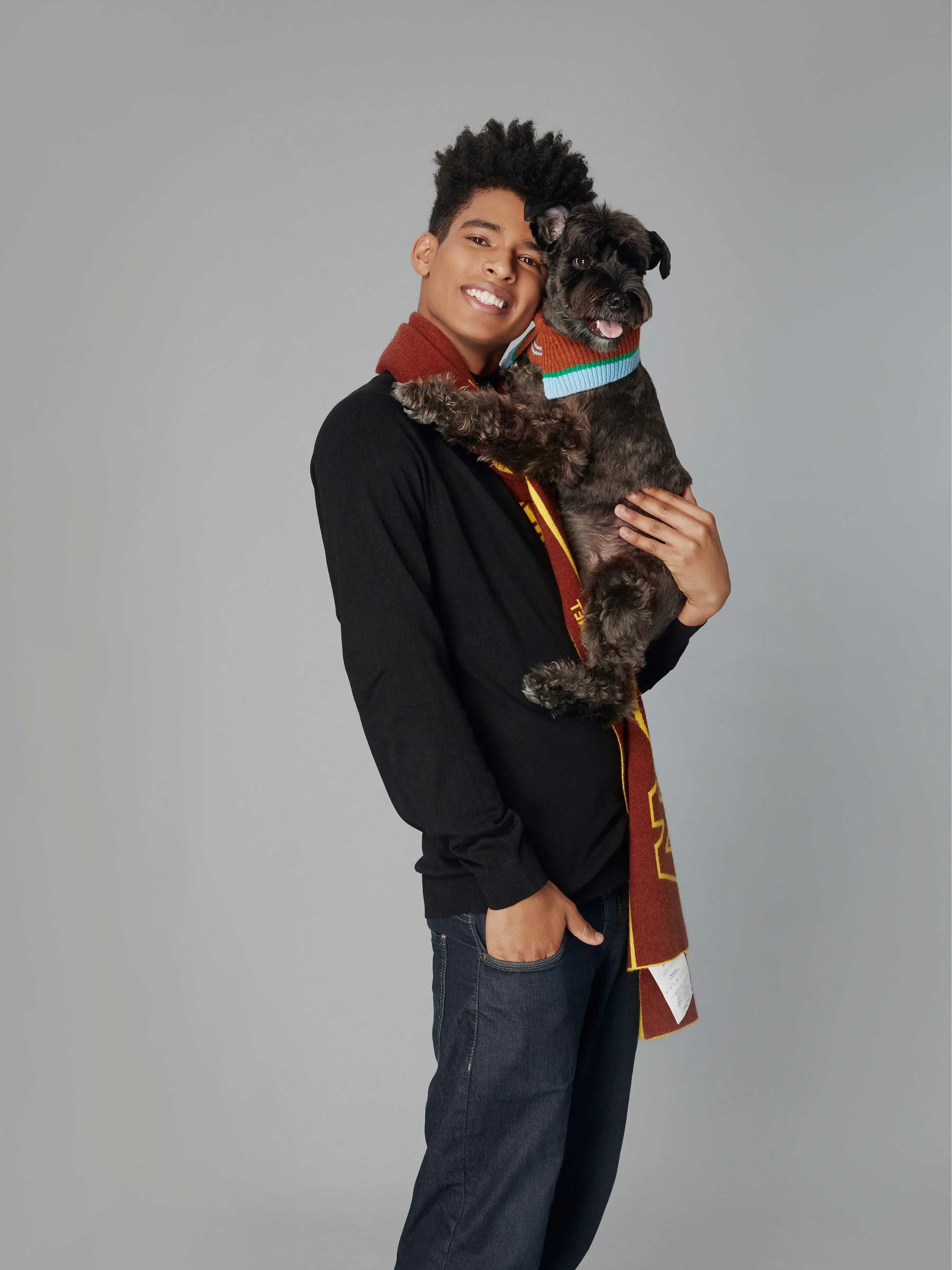 A man holding a small black dog wearing the Chestnut Brown fashion collar, highlighting pet-and-owner matching potential.
