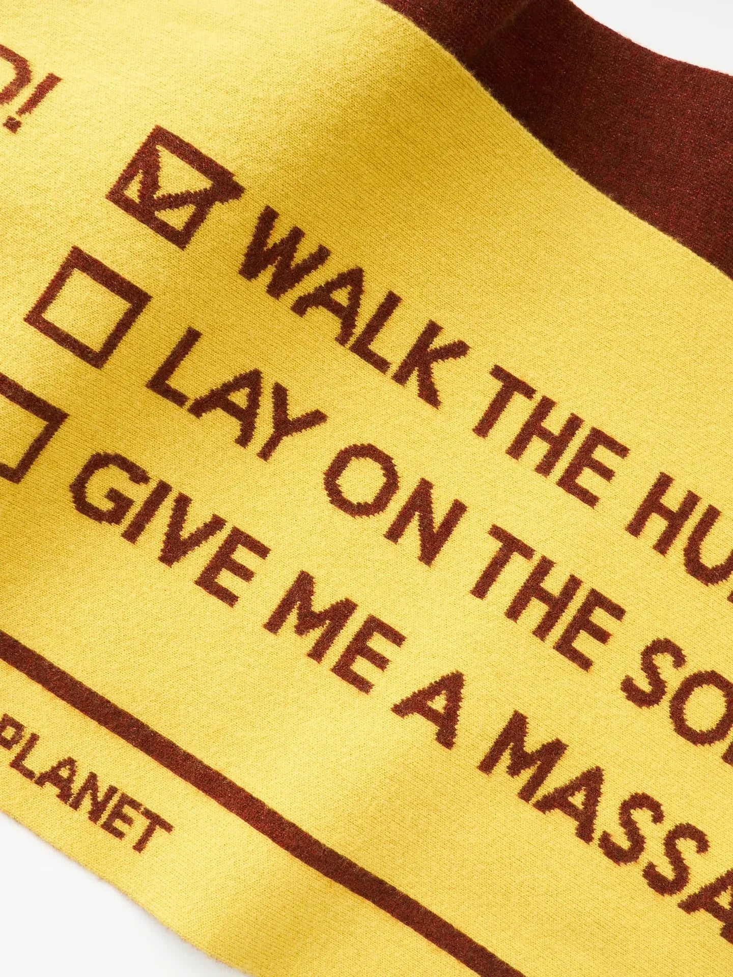 Close-up of the warm yellow side of the scarf showing the playful dog-life checklist typography