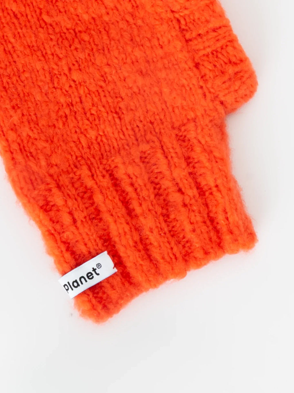 Detailed view of the flexible ribbed neck and "Yellow Planet" woven brand label on the persimmon red wool snood.