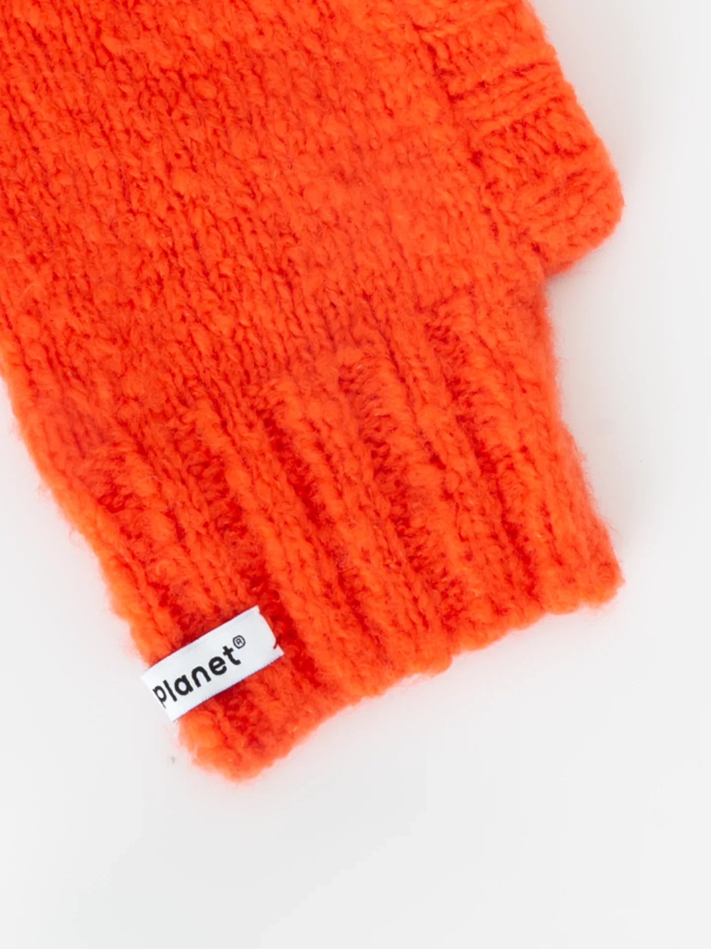 Detailed view of the flexible ribbed neck and "Yellow Planet" woven brand label on the persimmon red wool snood.