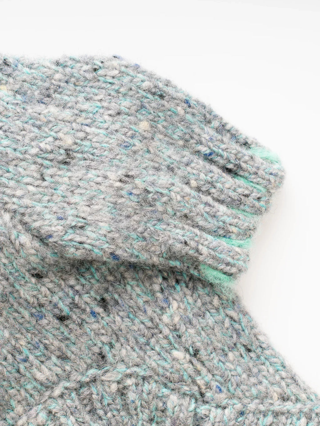 Close-up of the sleeve cuff on the Sage Tweed dog sweater, highlighting the mint green tipped ribbed edges.
