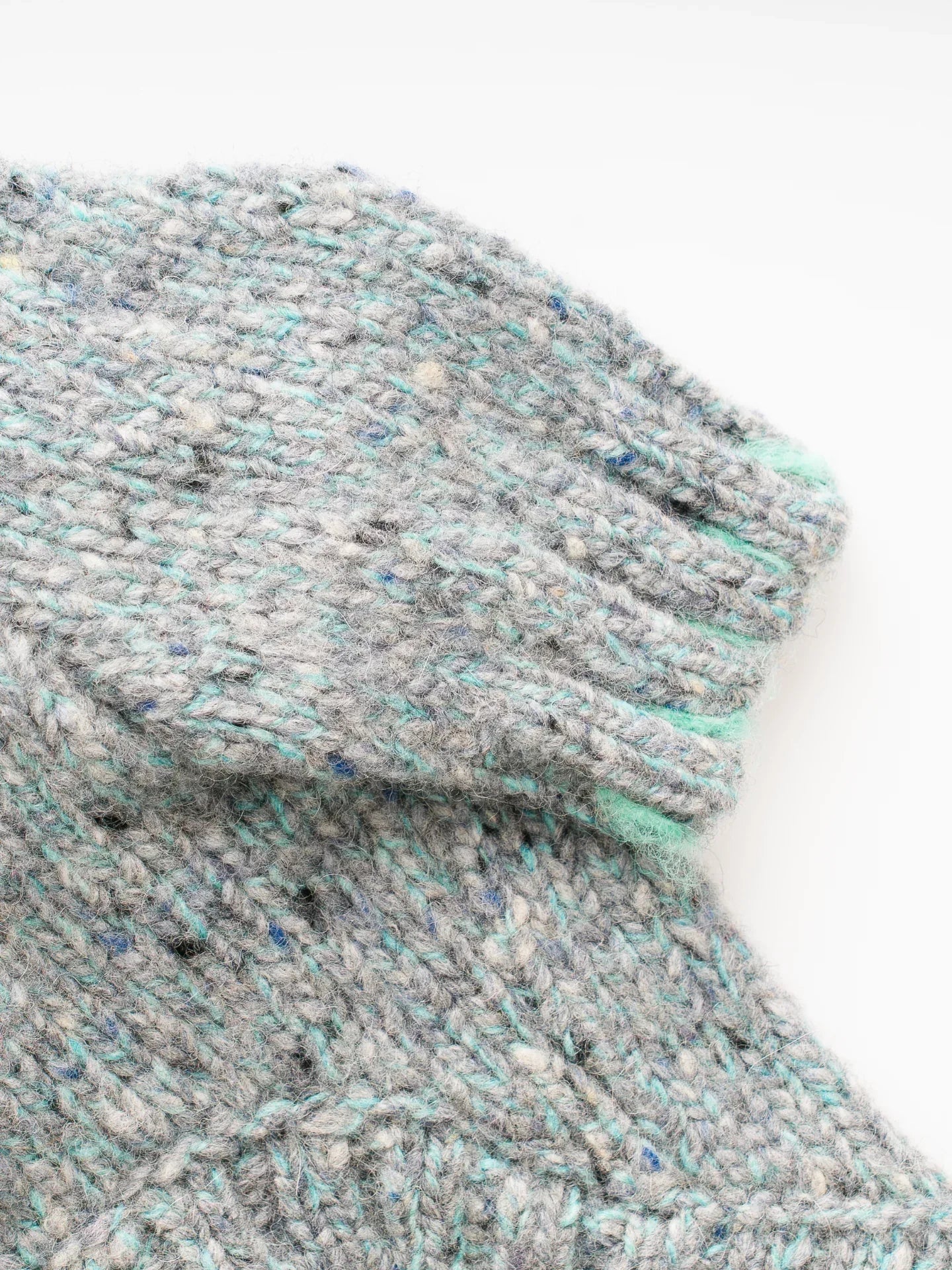 Close-up of the sleeve cuff on the Sage Tweed dog sweater, highlighting the mint green tipped ribbed edges.