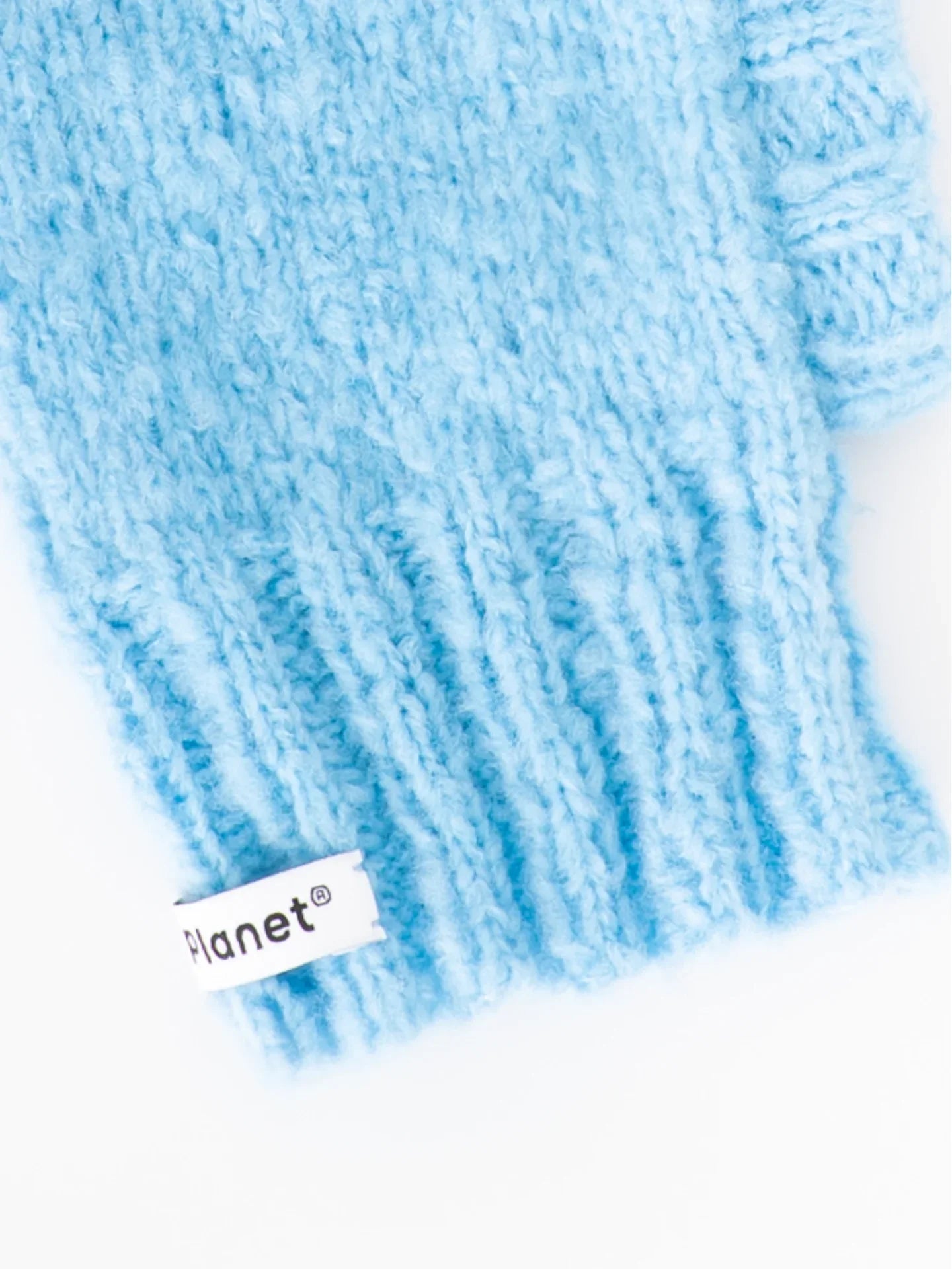 Detailed view of the flexible ribbed neck and "Planet" woven brand label on the sky blue fuzzy wool pet snood.