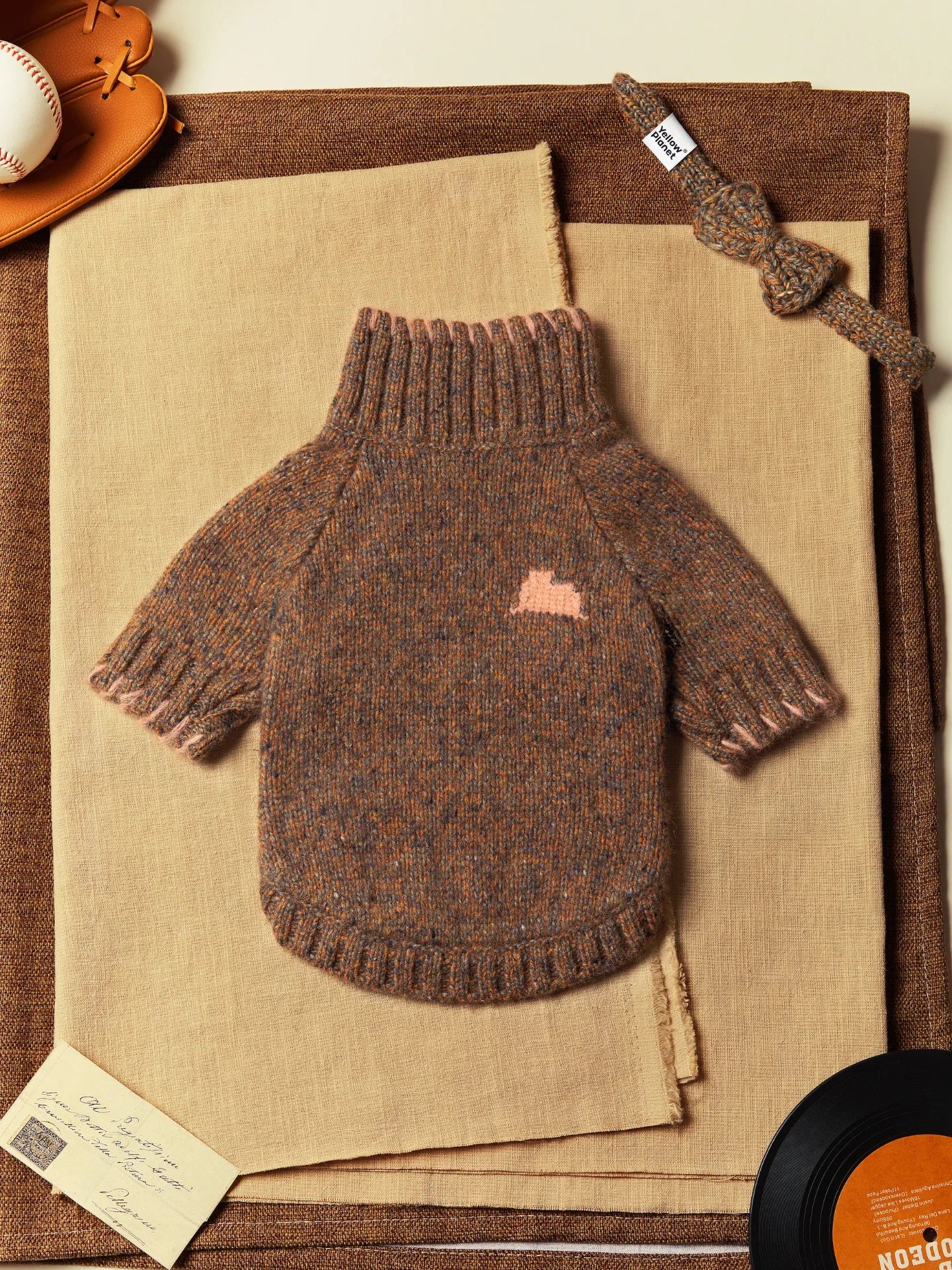 Flat lay of the Rust Tweed Alpaca-wool blend dog sweater featuring a pink intarsia accent and ribbed turtleneck.