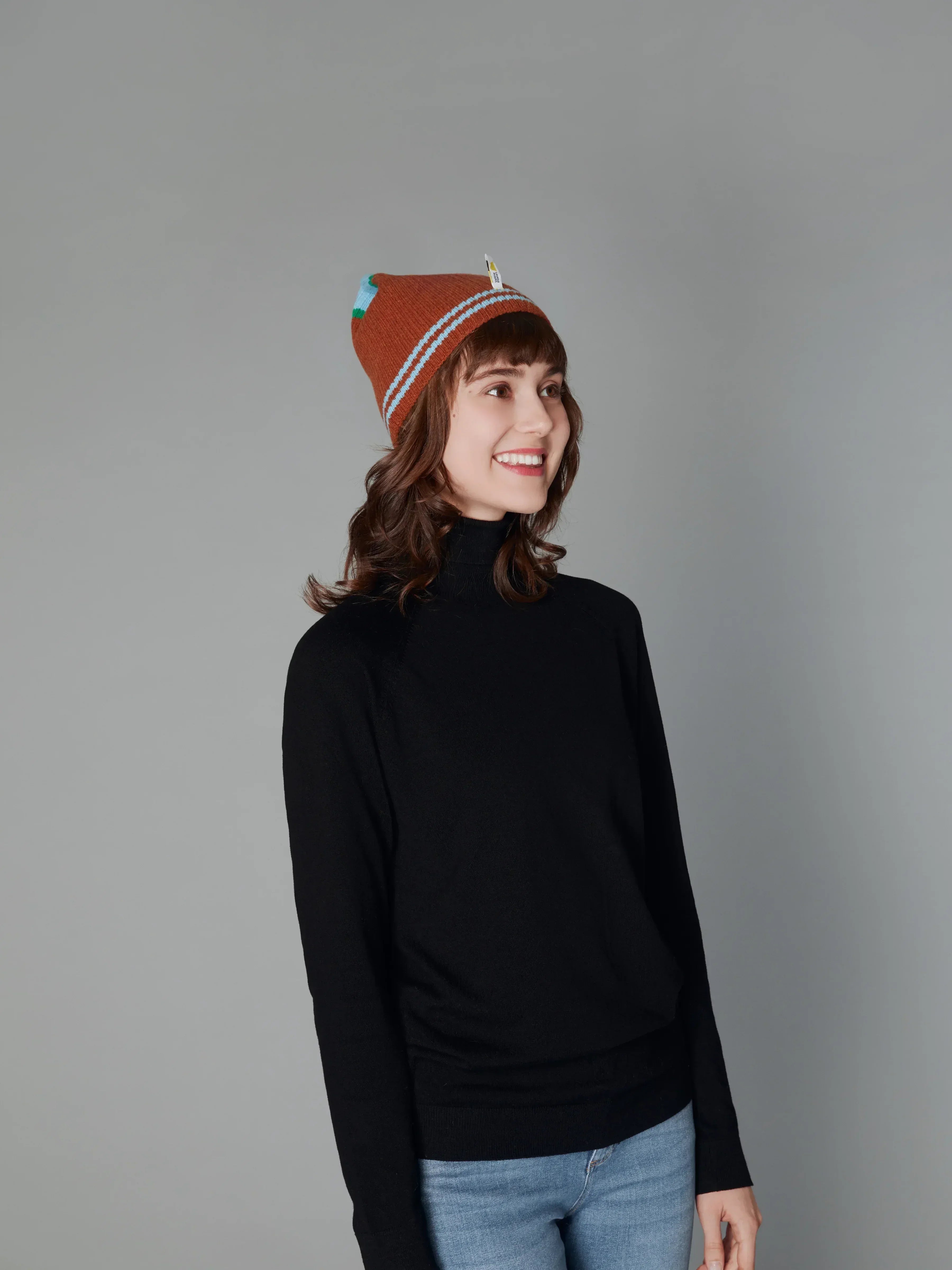 A woman wearing a matching cuffed beanie from the Color Heal series, demonstrating the collection's cohesive styling.