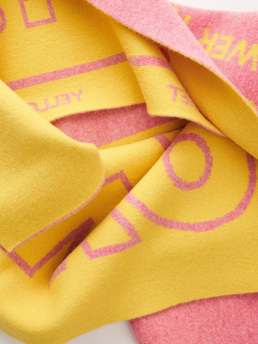 A neat, folded studio view of the "WOOF" theme scarf, displaying both the yellow and pink reversible sides.